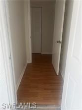 Hallway with dark wood-style floors and baseboards