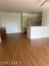 Kitchen view of white cabinets, freestanding refrigerator, and light countertops