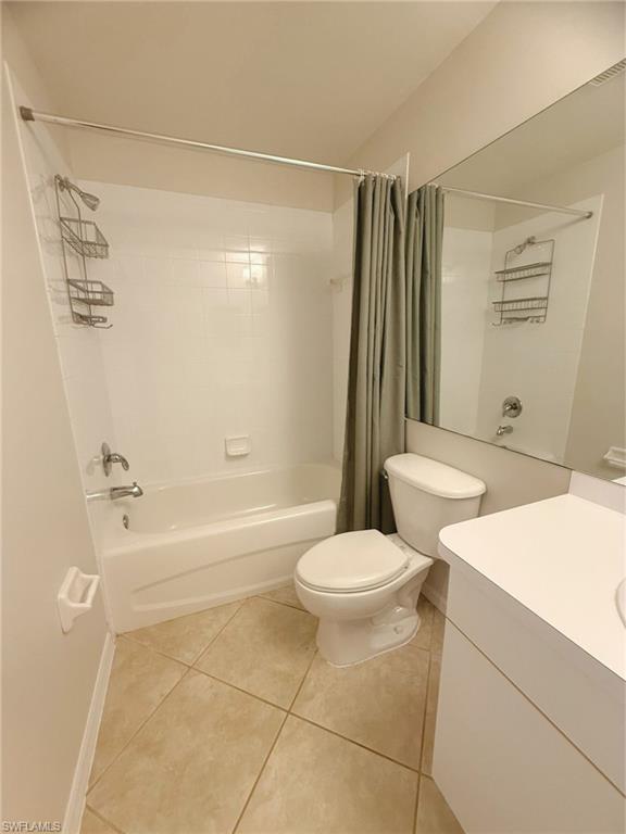 Bathroom with vanity, light tile patterned flooring, and shower / tub combo