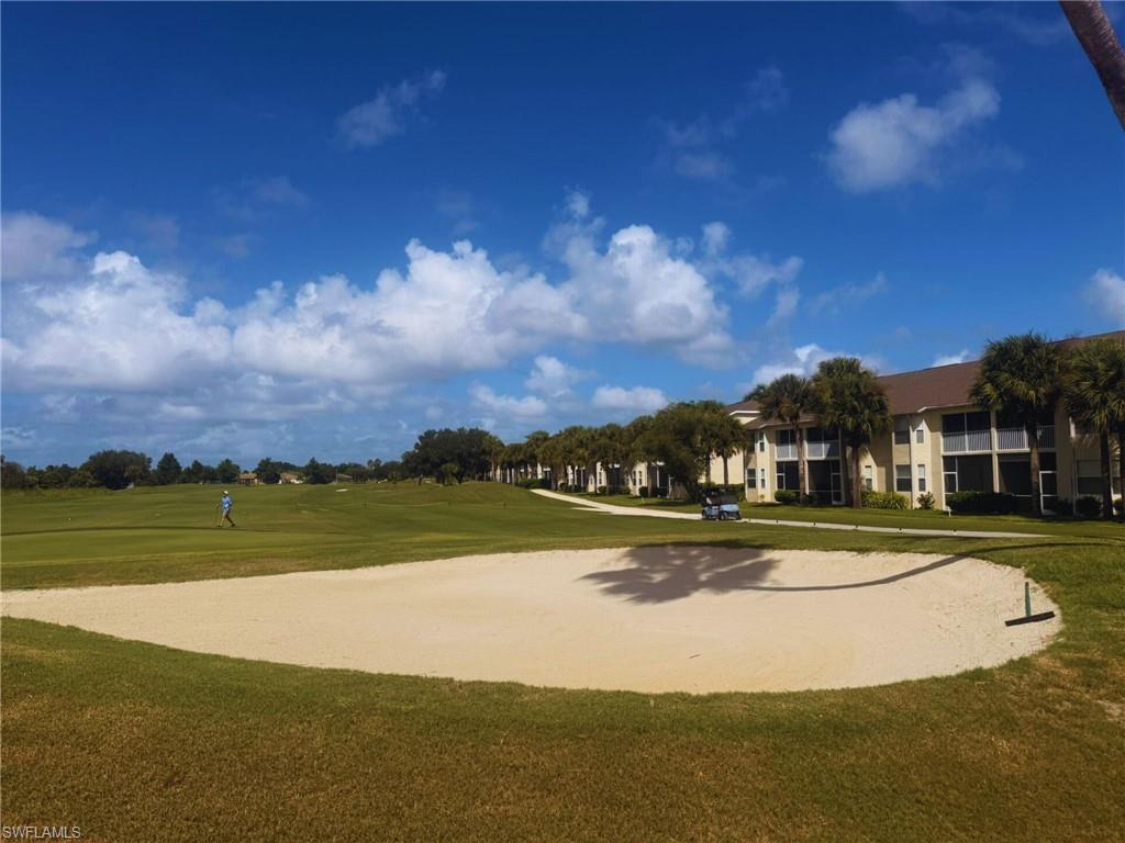 View of home's community featuring golf course view and a lawn