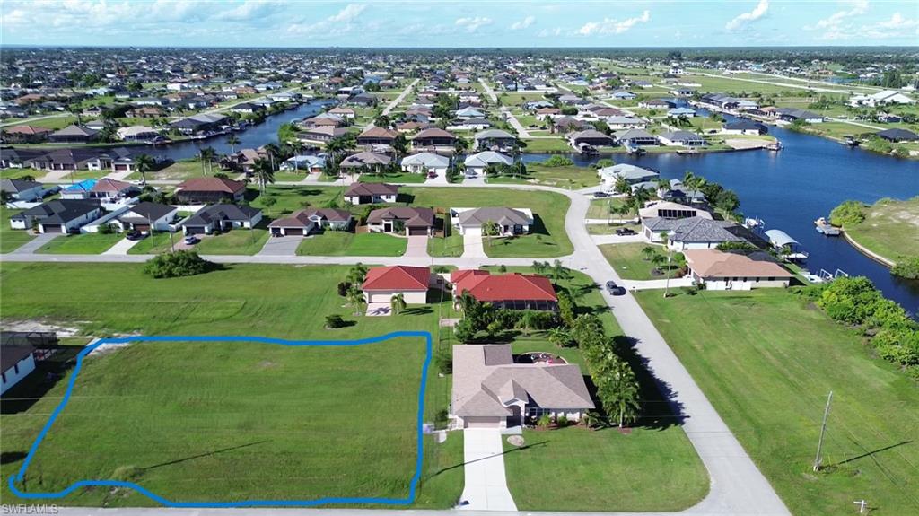 Aerial view of residential area with a large body of water and property parcel outlined