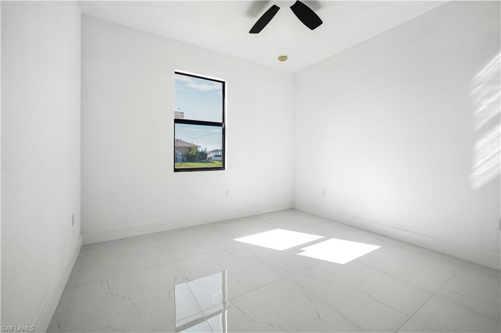 Spare room featuring baseboards and ceiling fan