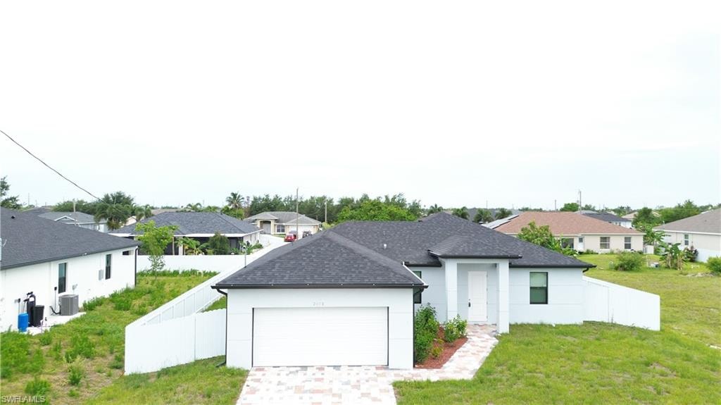 Light blue exterior with white trim, a dark shingle roof, and an attached two-car garage