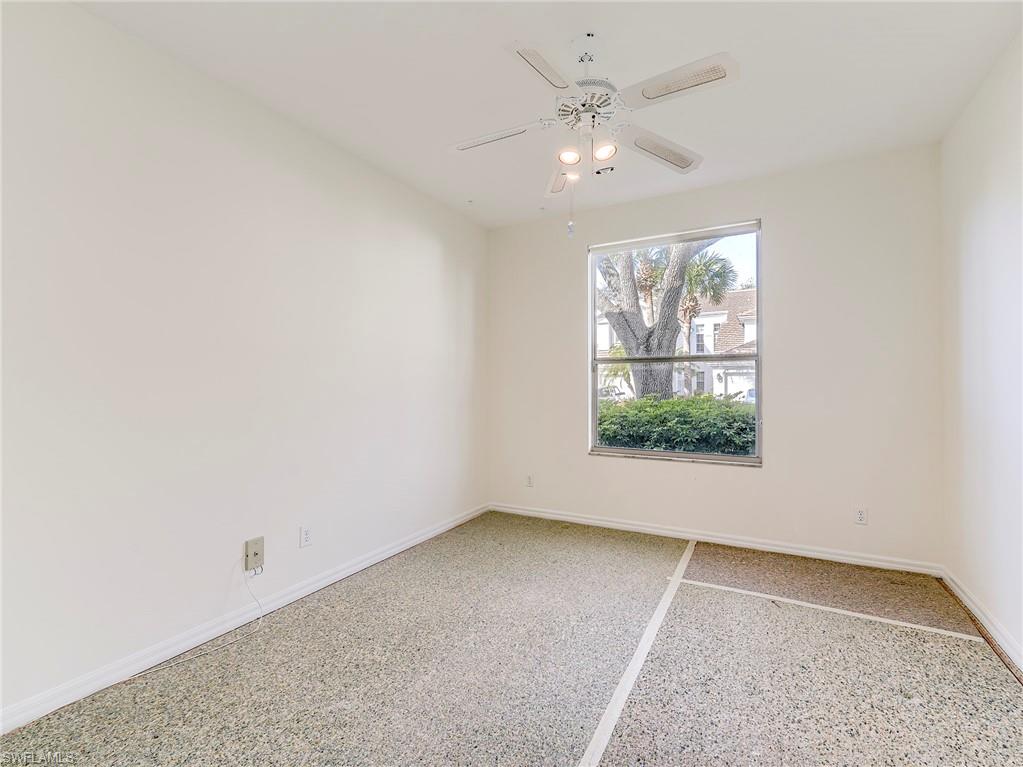 Spare room featuring dark speckled floor and ceiling fan