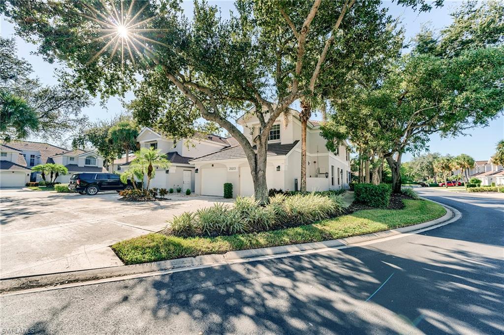 View of front facade featuring a residential view, a garage, stucco siding, and driveway