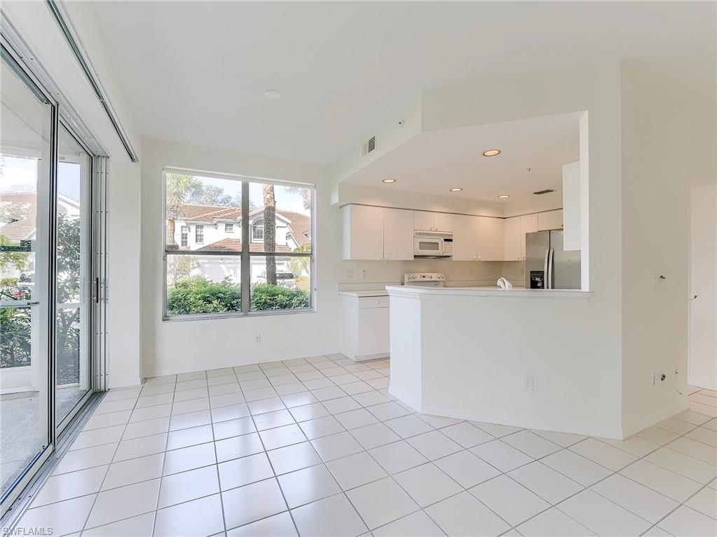 Kitchen featuring white cabinetry, white appliances, light countertops, recessed lighting, and a peninsula