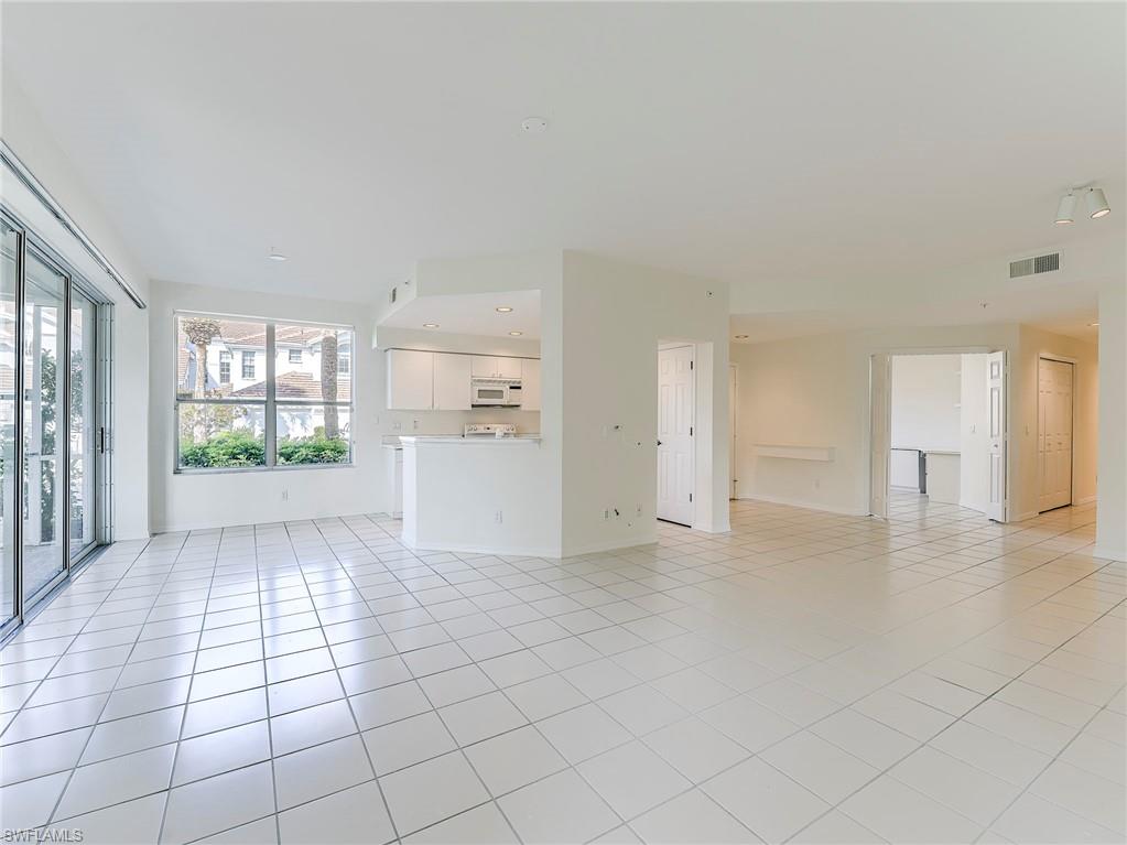 Unfurnished living room featuring light tile patterned floors and baseboards
