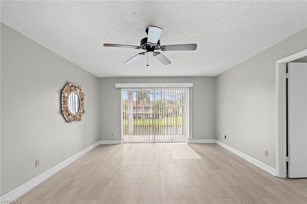 Unfurnished room featuring a textured ceiling, ceiling fan, and light wood finished floors
