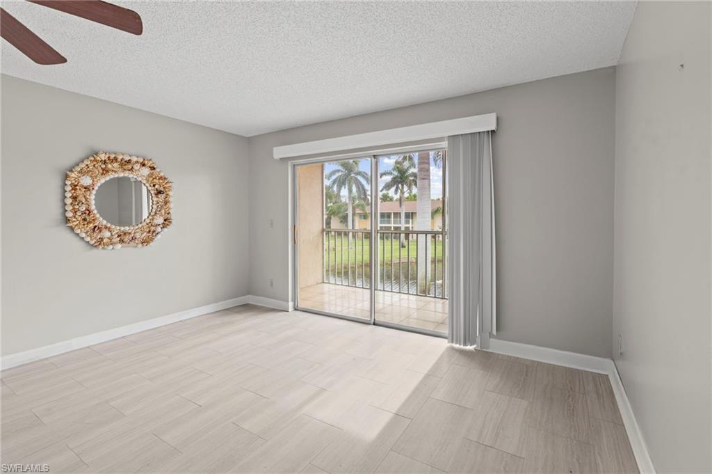 Unfurnished room featuring a textured ceiling, wood tiled floors, and a ceiling fan