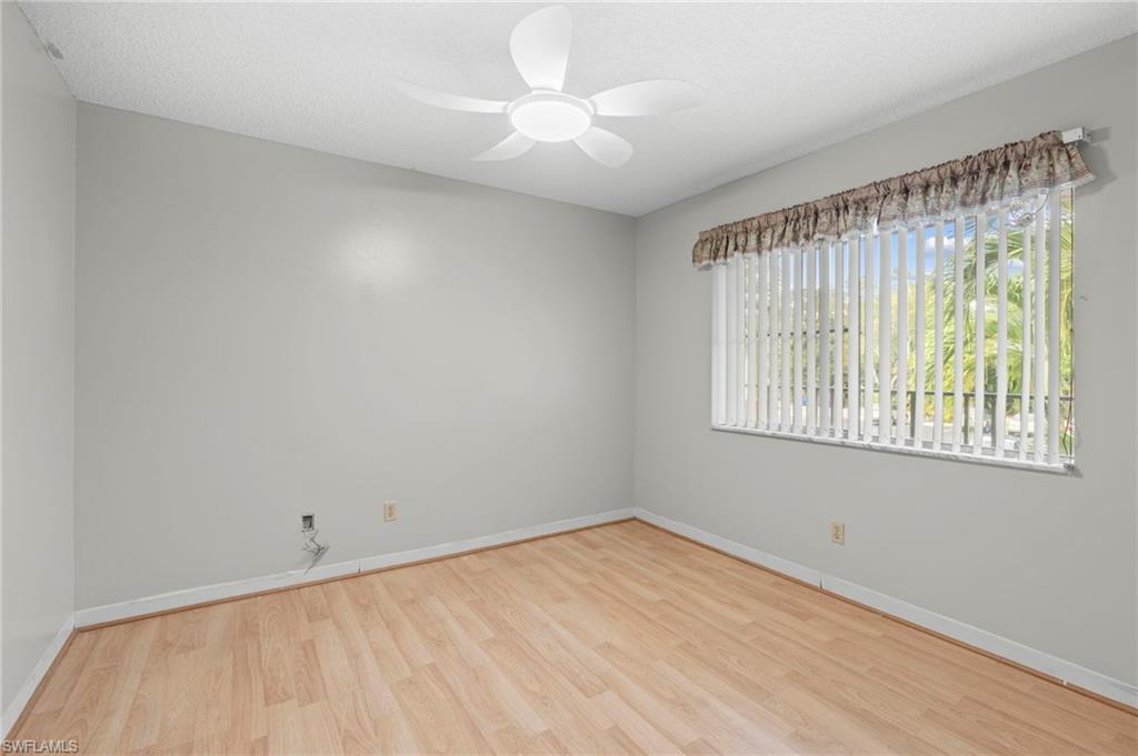 Unfurnished room featuring light wood-style floors, a ceiling fan, and a textured ceiling