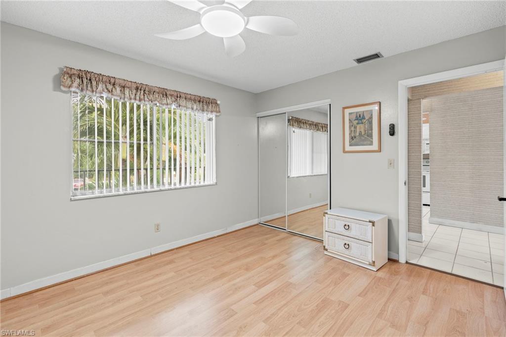 Unfurnished bedroom featuring light wood finished floors, a closet, a textured ceiling, and a ceiling fan