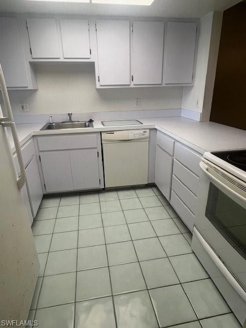 Kitchen with range, light tile patterned floors, light countertops, and white dishwasher