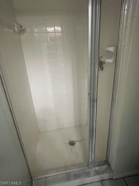 Full bath with a stall shower and tile patterned flooring