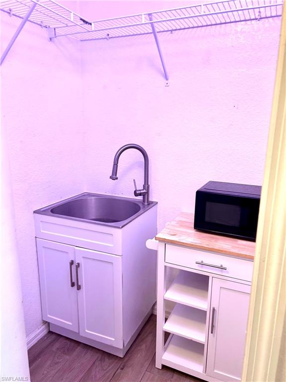Bathroom featuring double vanity, light wood-type flooring, and a closet