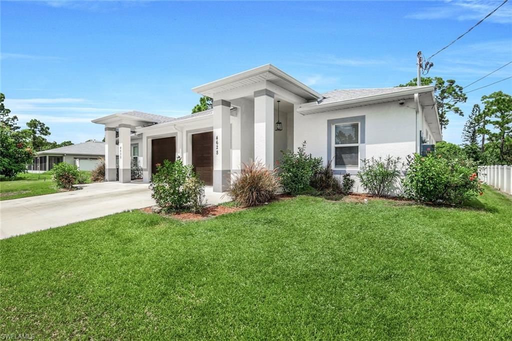 View of front of home with stucco siding, driveway, a garage, and a shingled roof