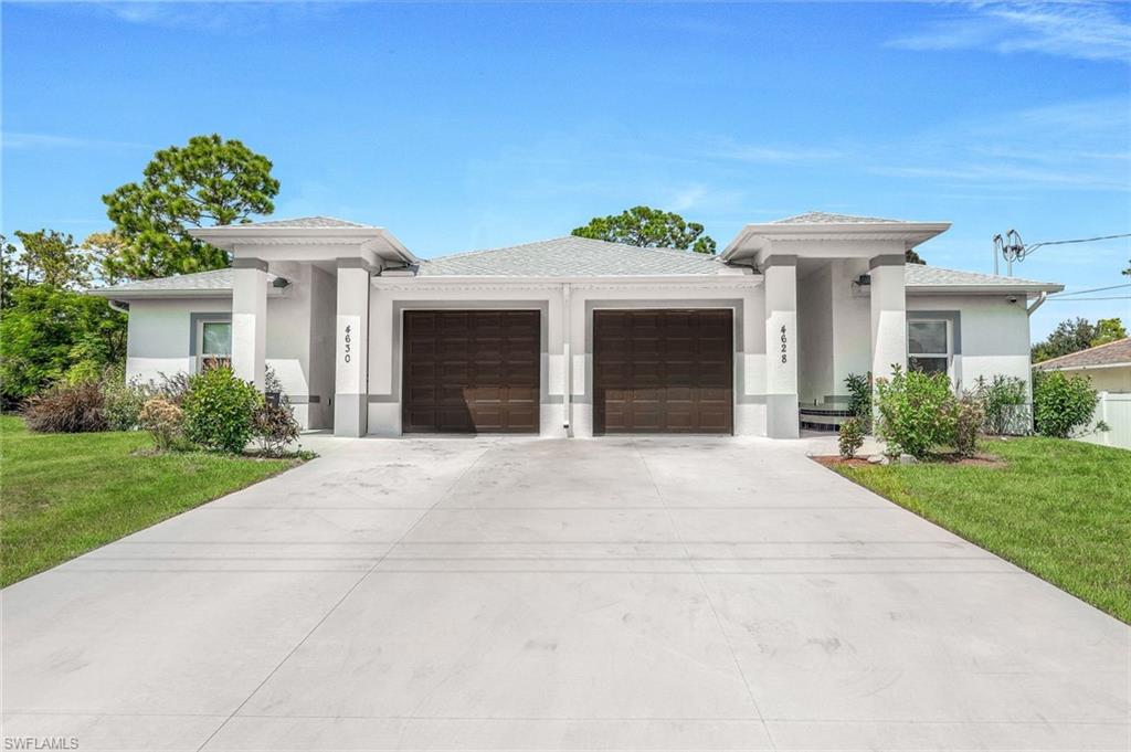 Prairie-style house featuring a front lawn, stucco siding, a garage, and concrete driveway