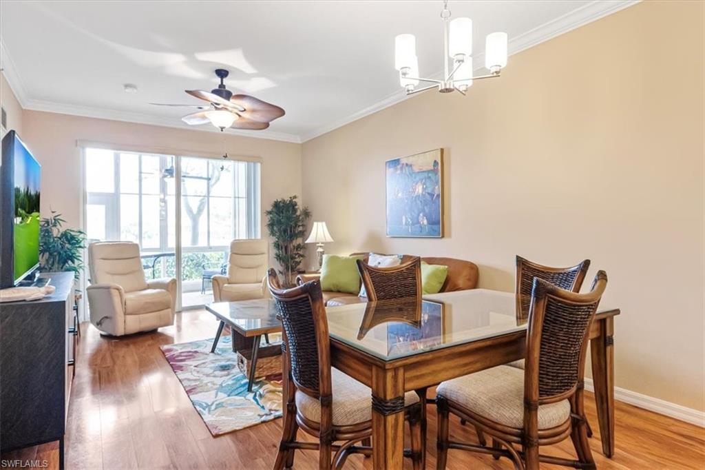 Dining space featuring ornamental molding, light wood-style floors, ceiling fan, and a chandelier