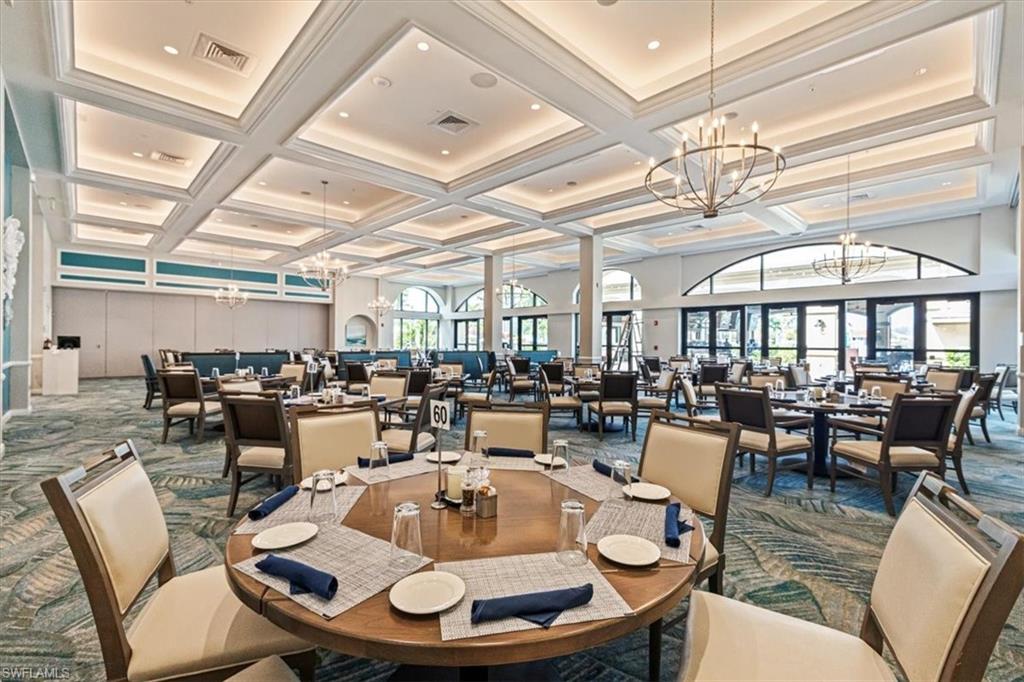 Dining area with carpet flooring, a chandelier, coffered ceiling, and beamed ceiling