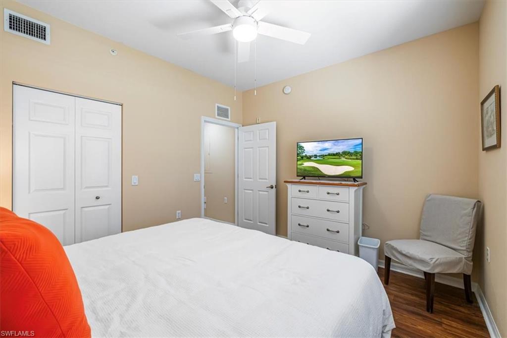 Bedroom with dark wood-type flooring, a ceiling fan, and a closet
