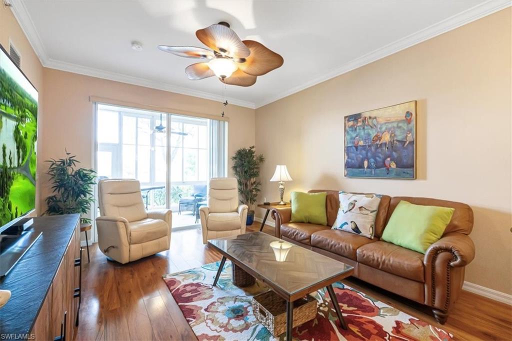 Living area featuring crown molding, wood finished floors, and ceiling fan