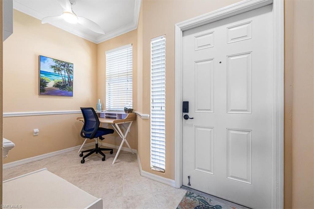 Home office featuring ornamental molding, light tile patterned flooring, and a ceiling fan