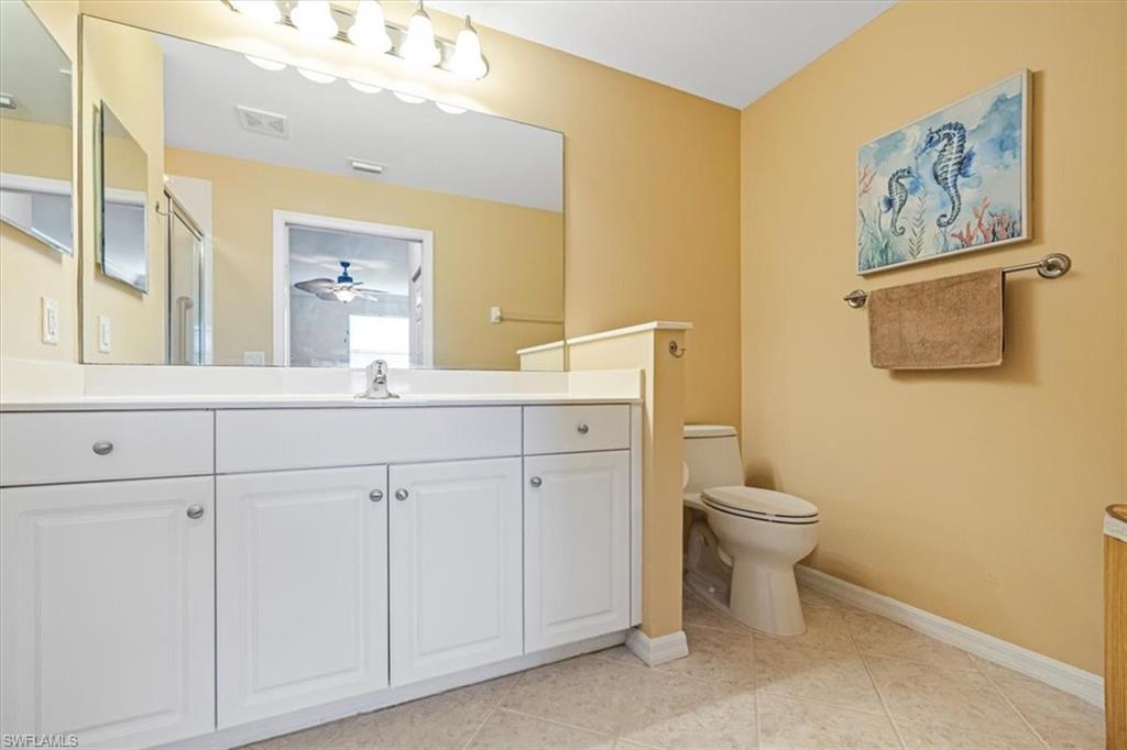 Full bath with vanity, light tile patterned floors, and a ceiling fan