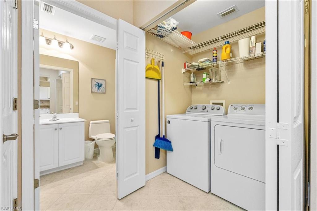 Laundry room featuring independent washer and dryer and light tile patterned floors