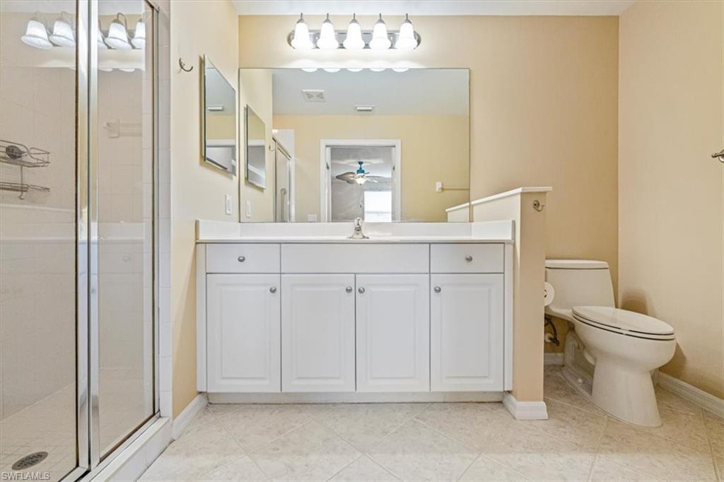 Bathroom featuring a shower stall, vanity, and light tile patterned floors