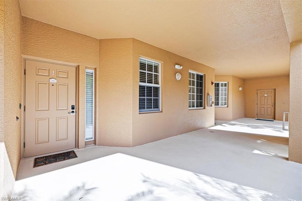 Property entrance featuring stucco siding and a patio area