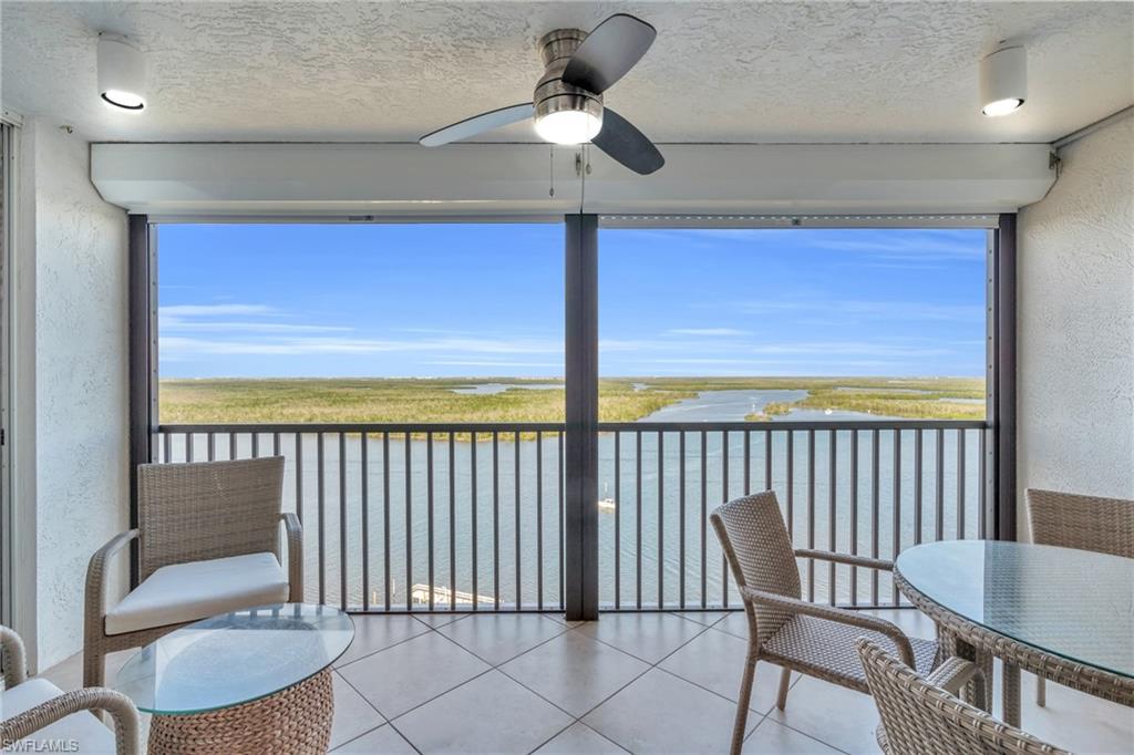 Sunroom / solarium with a water view and ceiling fan virtually enhanced image