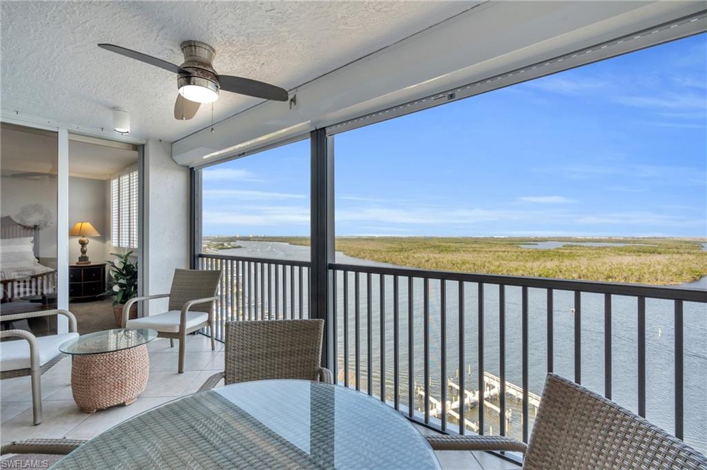 Balcony featuring ceiling fan and a water view virtually enhanced image