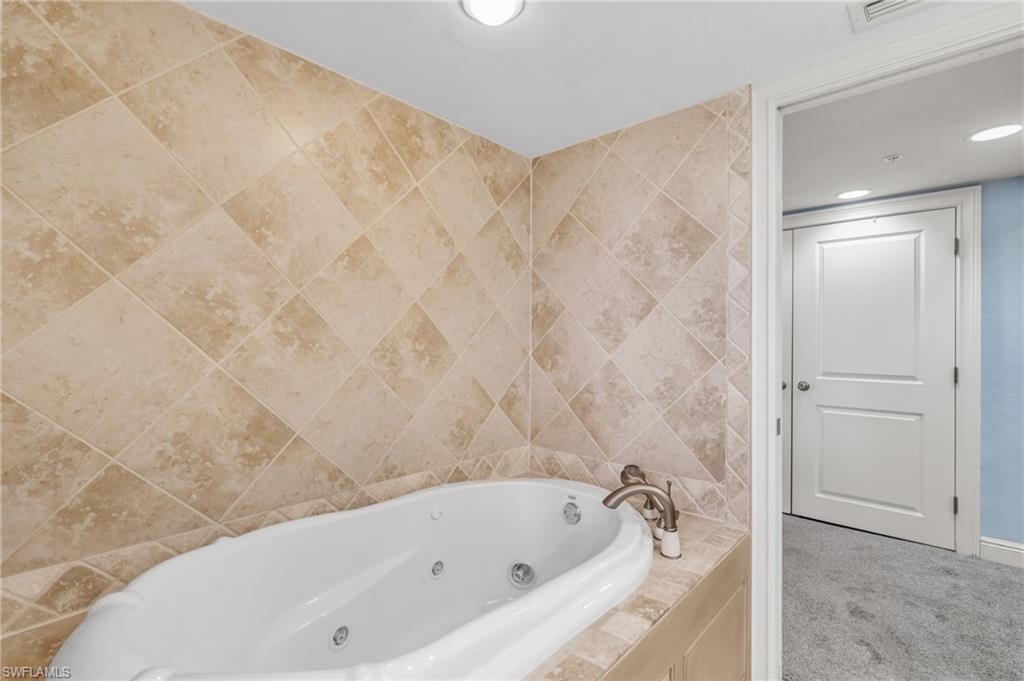 Bathroom with tiled tub and tile walls / virtually enhanced image