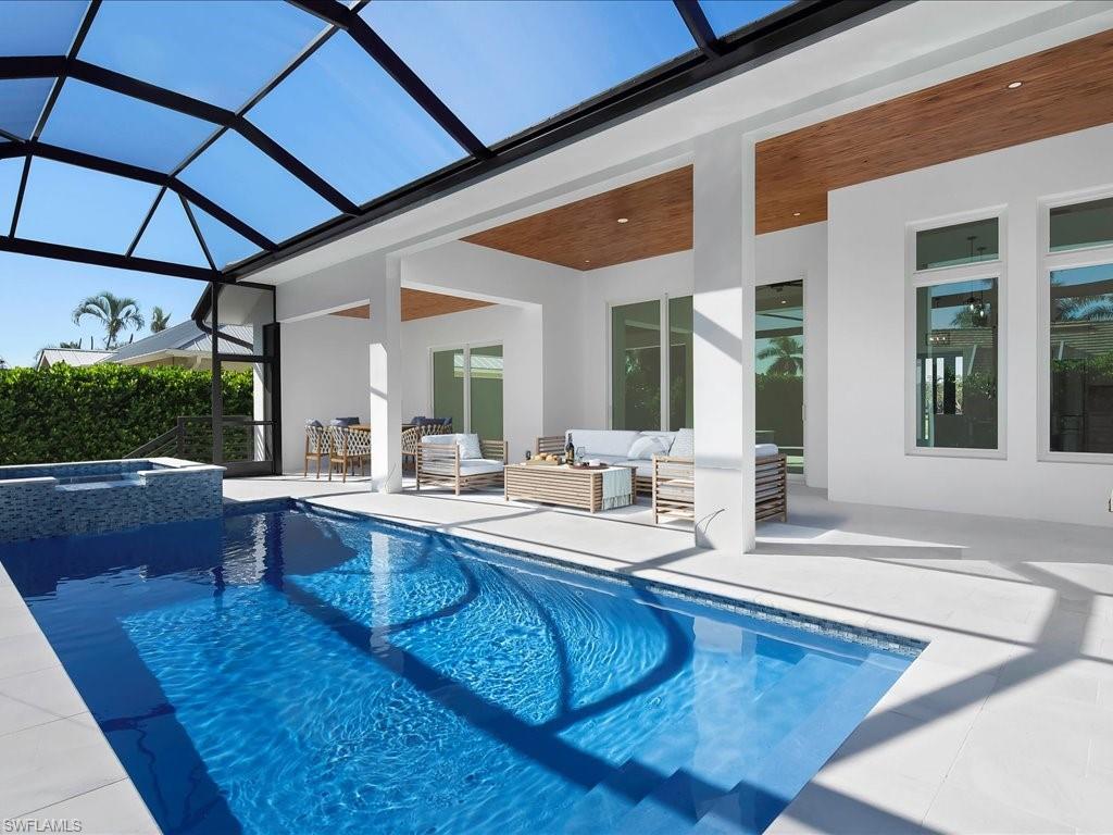 View of pool featuring an outdoor hangout area, a sunroom, a lanai, a patio area, and a pool with connected hot tub
