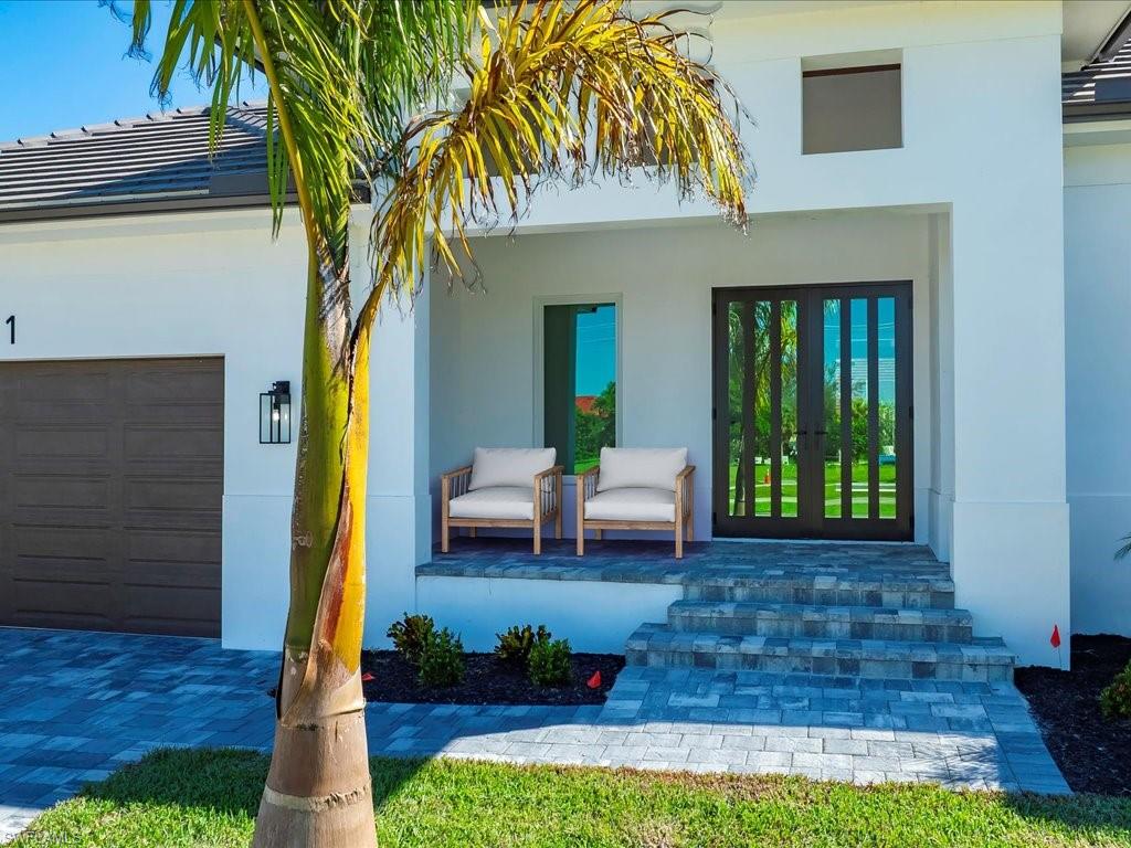 Virtually Staged- View of exterior entry with stucco siding, french doors, and an attached garage