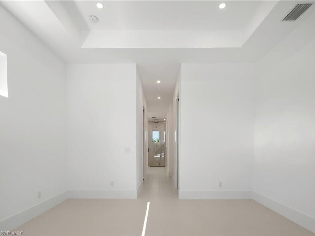Unfurnished room with recessed lighting and a raised ceiling