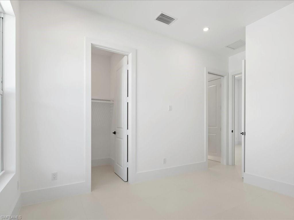 Unfurnished bedroom featuring a spacious closet and recessed lighting