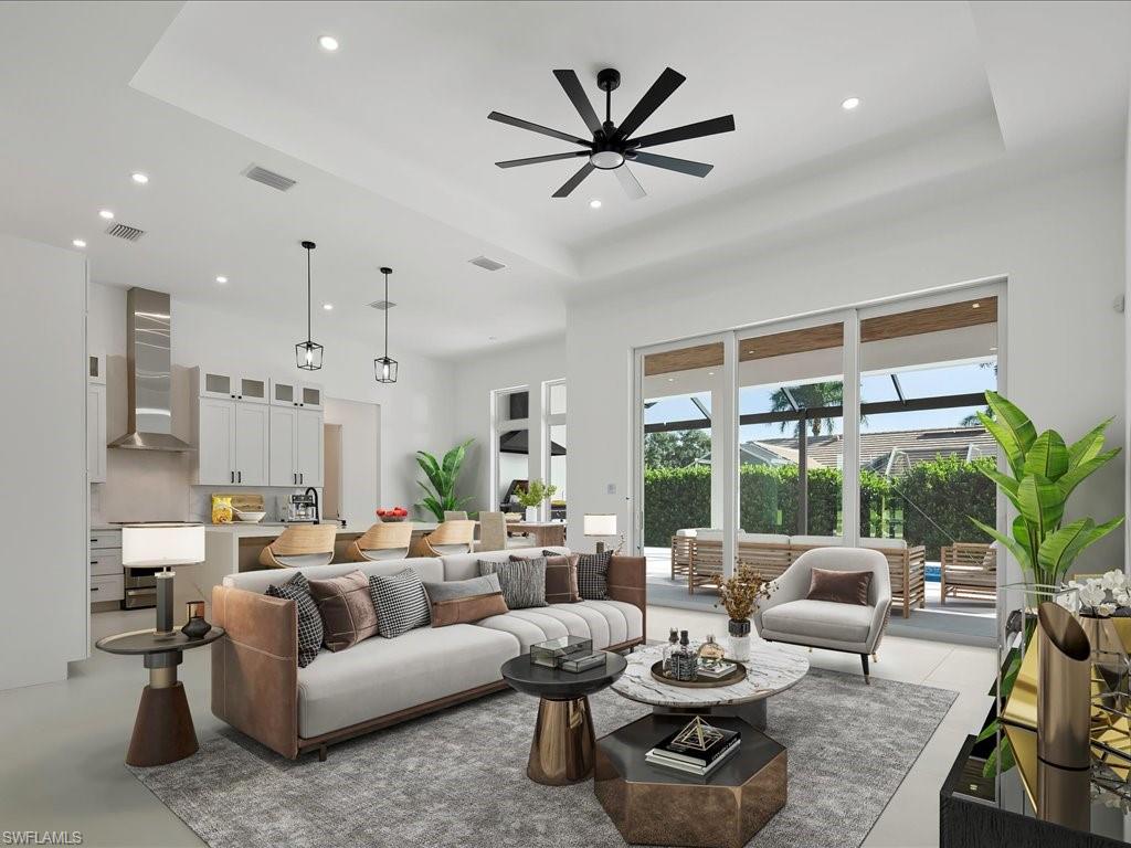 Virtually Staged- Living room with a raised ceiling, recessed lighting, ceiling fan, a towering ceiling, and finished concrete flooring