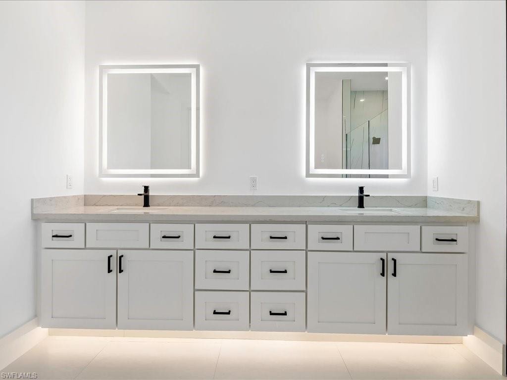 Bathroom featuring double vanity and light tile patterned flooring