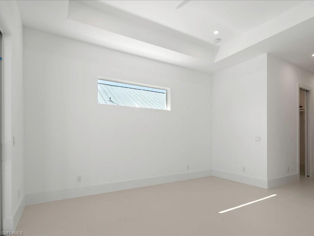 Unfurnished room featuring a tray ceiling and recessed lighting