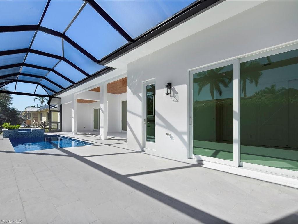 View of swimming pool with a sunroom, a patio, a pool with connected hot tub, and a lanai