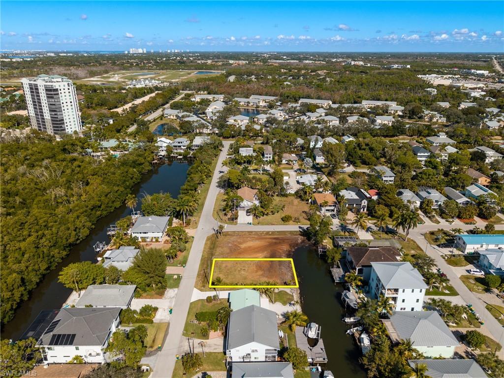 Aerial view of property's location featuring nearby suburban area, property boundaries highlighted, and a large body of water
