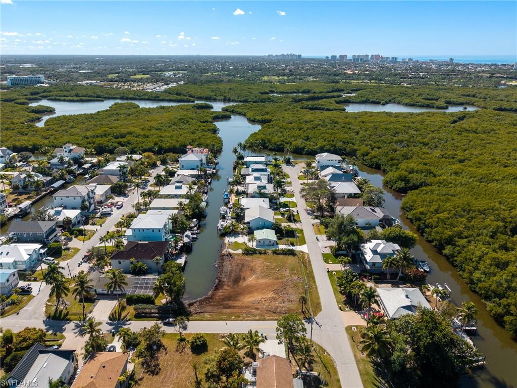 Aerial view of property's location featuring a nearby body of water and nearby suburban area