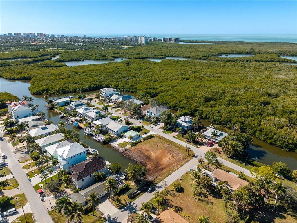 Aerial view of property and surrounding area with a large body of water and nearby suburban area