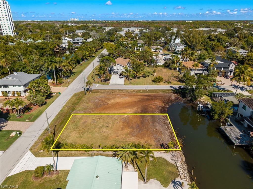 Aerial view of property and surrounding area with a nearby body of water and property parcel outlined