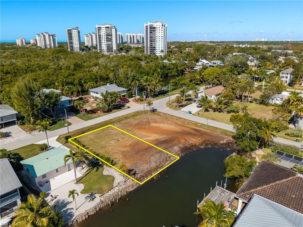View of urban area with property boundaries highlighted and a nearby body of water