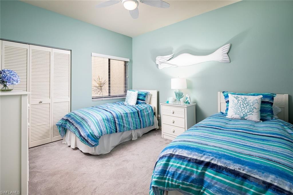 Carpeted bedroom with a closet and a ceiling fan