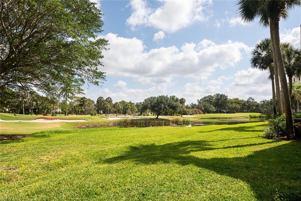 View of home's community with a lawn, golf course view, and a water view