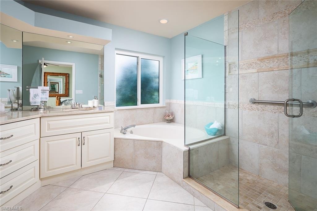 Bathroom featuring a shower stall, ceiling fan, tile patterned floors, a garden tub, and vanity
