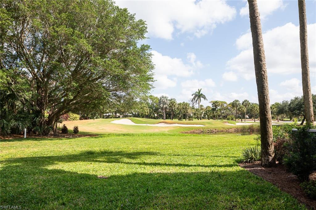 View of property's community featuring a lawn and view of golf course