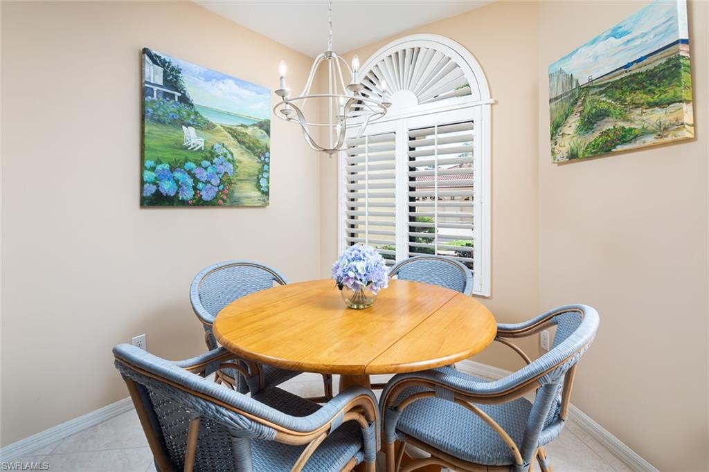 Dining room featuring a chandelier and baseboards